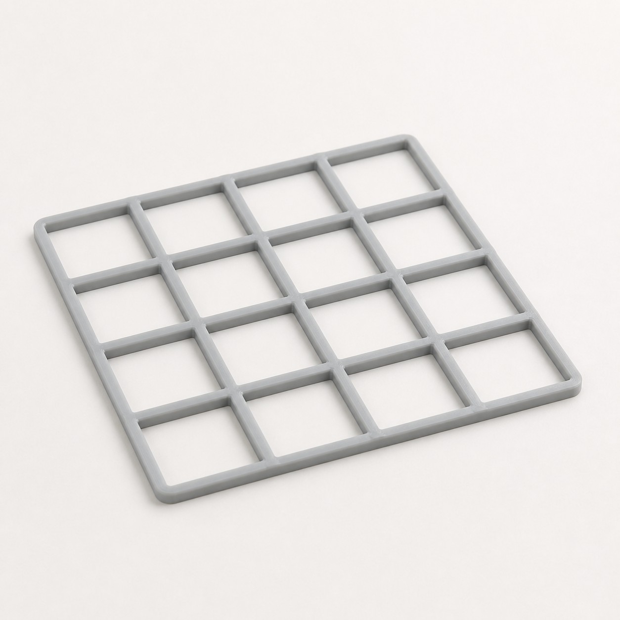 A gray 4 by 4 Gridfinity baseplate photographed on a plain white background, showing the raised grid walls